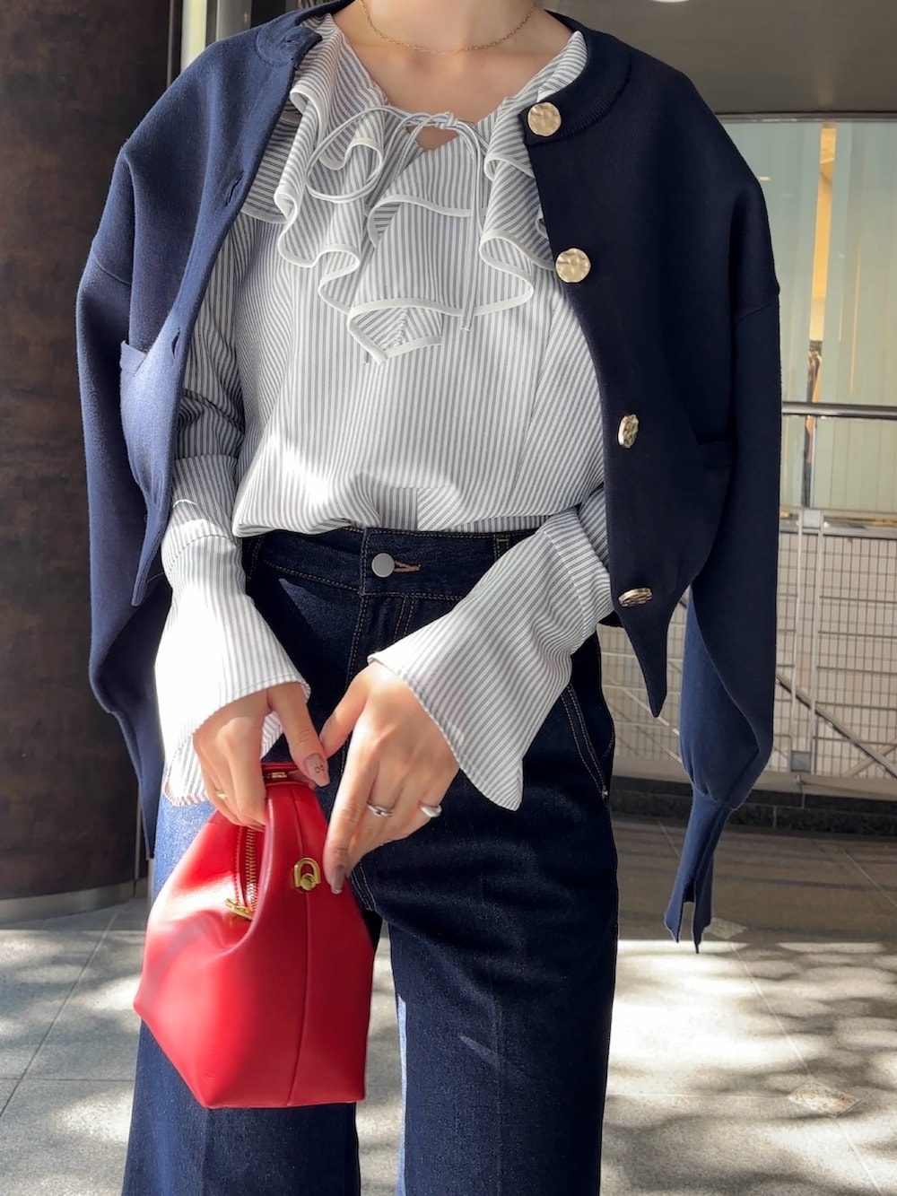 ホワイト系のシャツ/ブラウス、ブルー系のカーディガン/ボレロ、レッド系のハンドバッグを着用したレディースの冬コーディネートの9枚目の写真