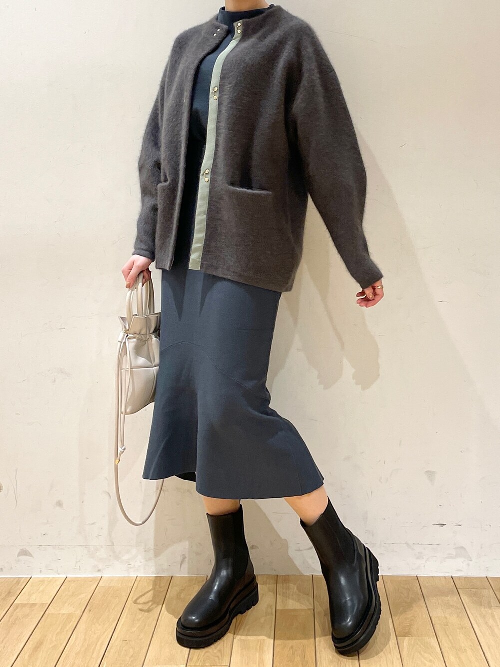 グレー系のカーディガン/ボレロ、グリーン系のニット/セーター、グリーン系のスカートを着用したレディースの冬コーディネートの5枚目の写真