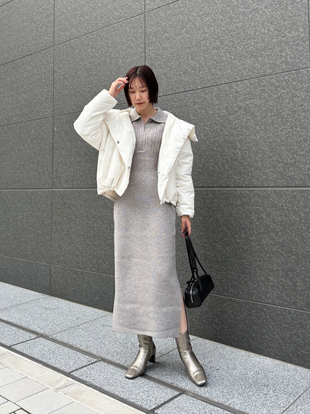 グレー系のワンピース、ホワイト系のダウンジャケット/コート、ブラック系のショルダーバッグを着用したレディースの秋コーディネートの2枚目の写真