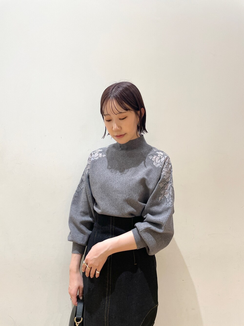 ベージュ系のブーツ、ブラック系のデニムスカート、ブラック系のハンドバッグを着用したレディースの夏コーディネートの6枚目の写真