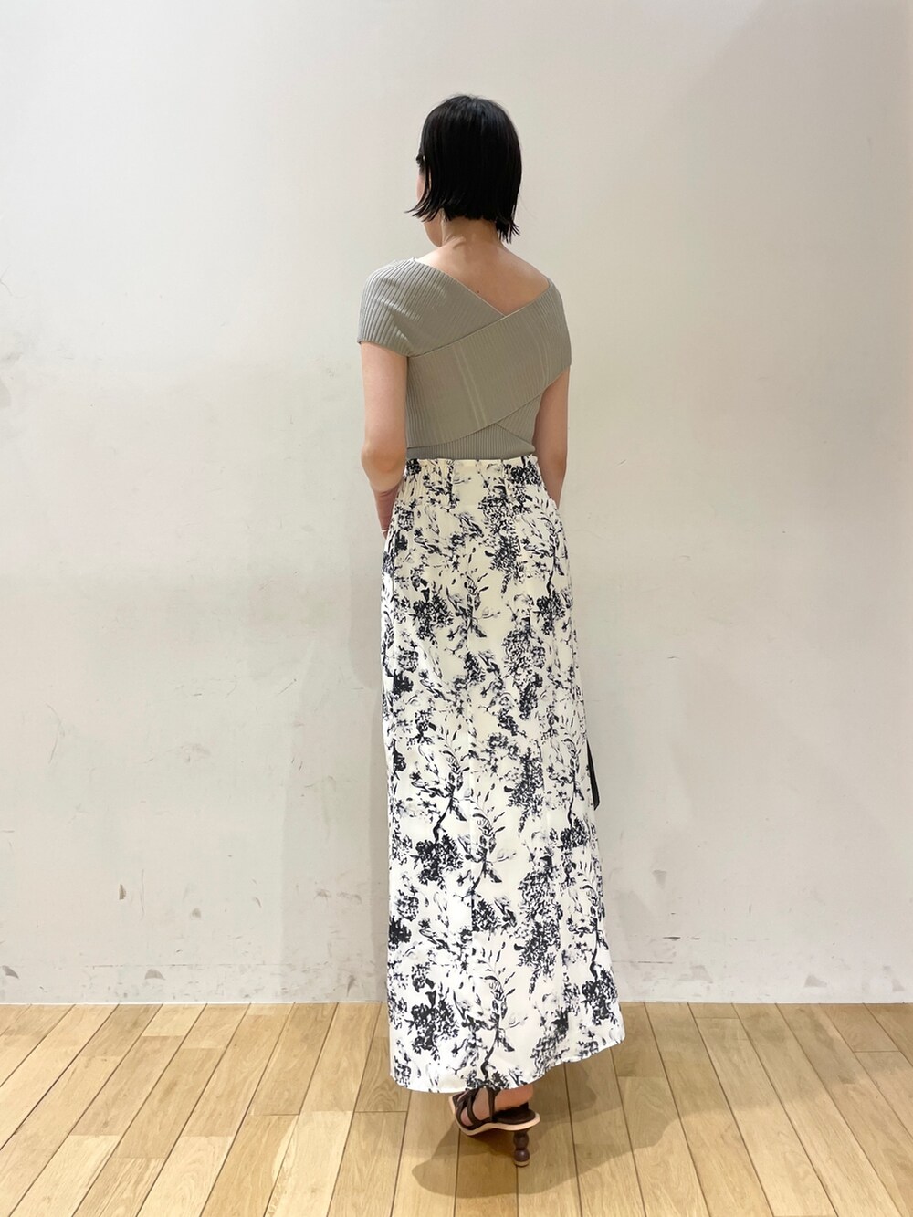 グリーン系のニット/セーター、ブルー系のスカート、ブラウン系のサンダルを着用したレディースの夏コーディネートの4枚目の写真