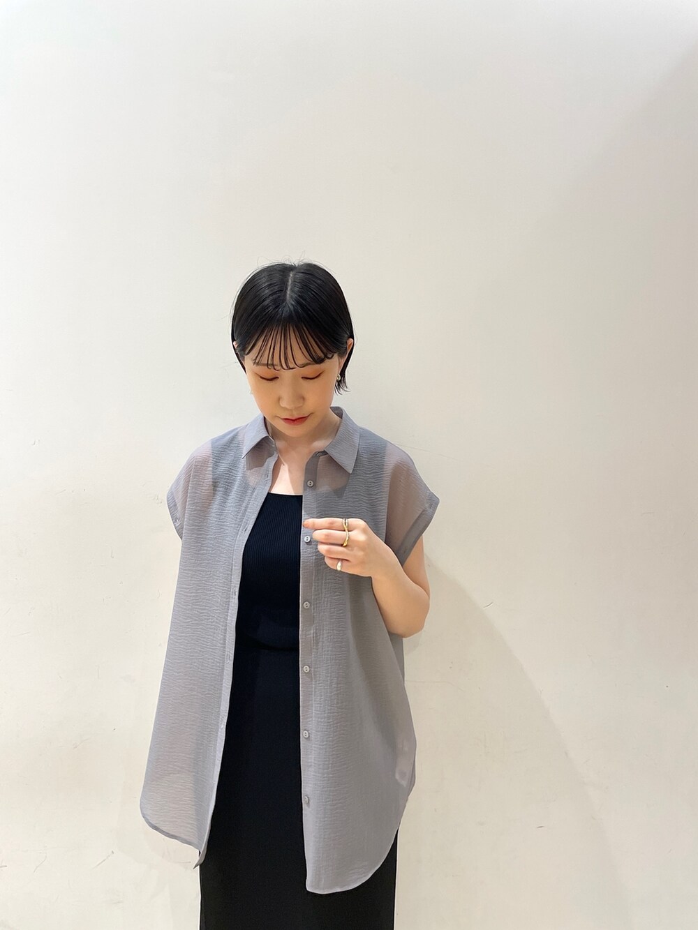 ブラック系のスカート、ブラウン系のハンドバッグ、ブラック系のサンダルを着用したレディースの春コーディネートの7枚目の写真