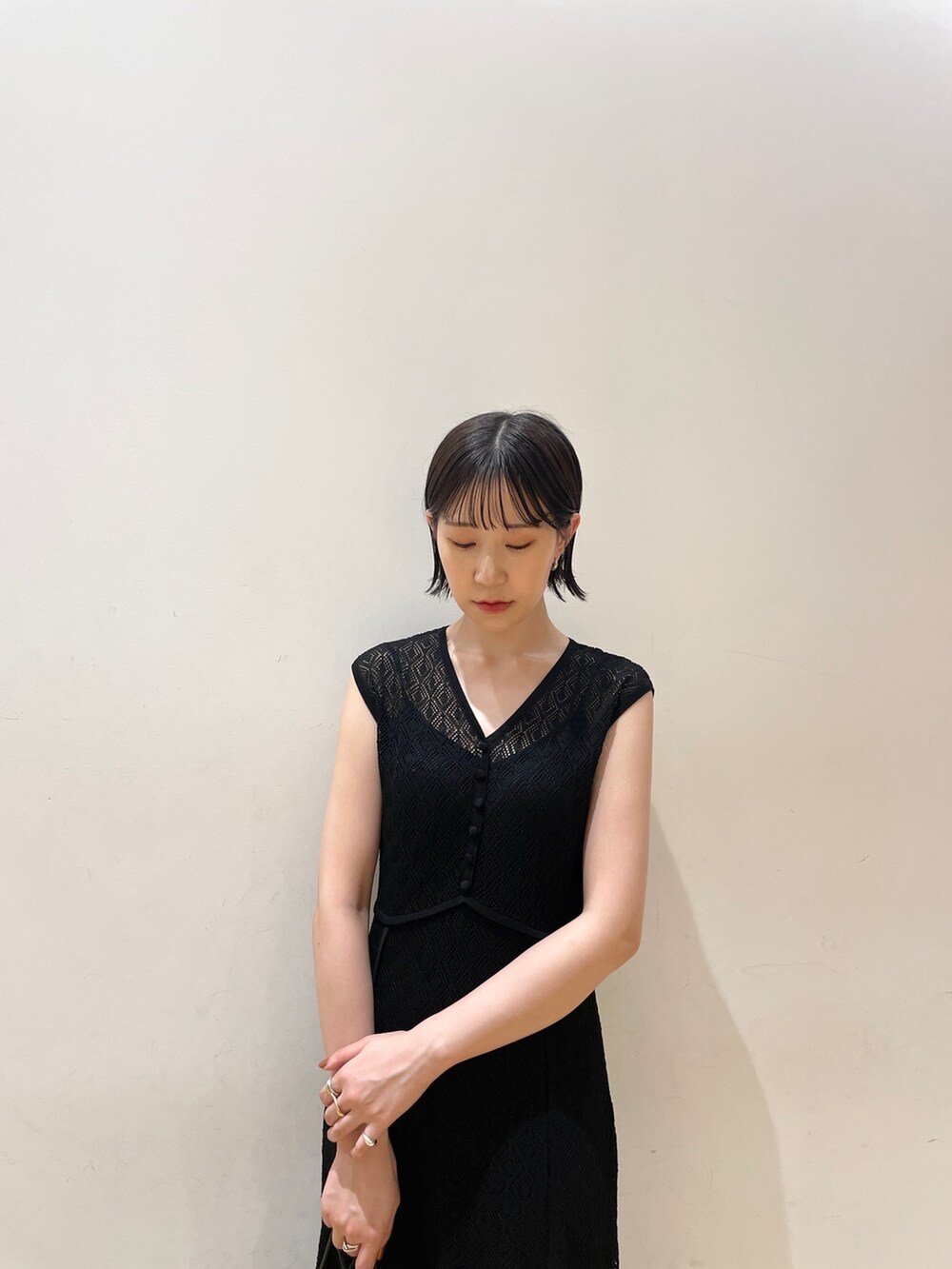 ブラック系のワンピース、ブラック系のハンドバッグ、ブラウン系のサンダルを着用したレディースの夏コーディネートの7枚目の写真