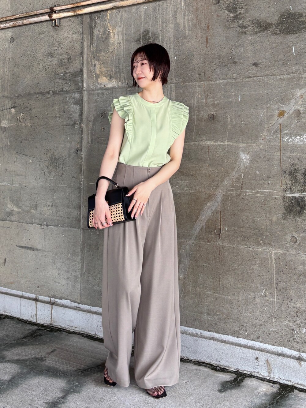 ブラウン系のその他パンツ、グリーン系のシャツ/ブラウス、ブラック系のハンドバッグを着用したレディースの夏コーディネートの2枚目の写真