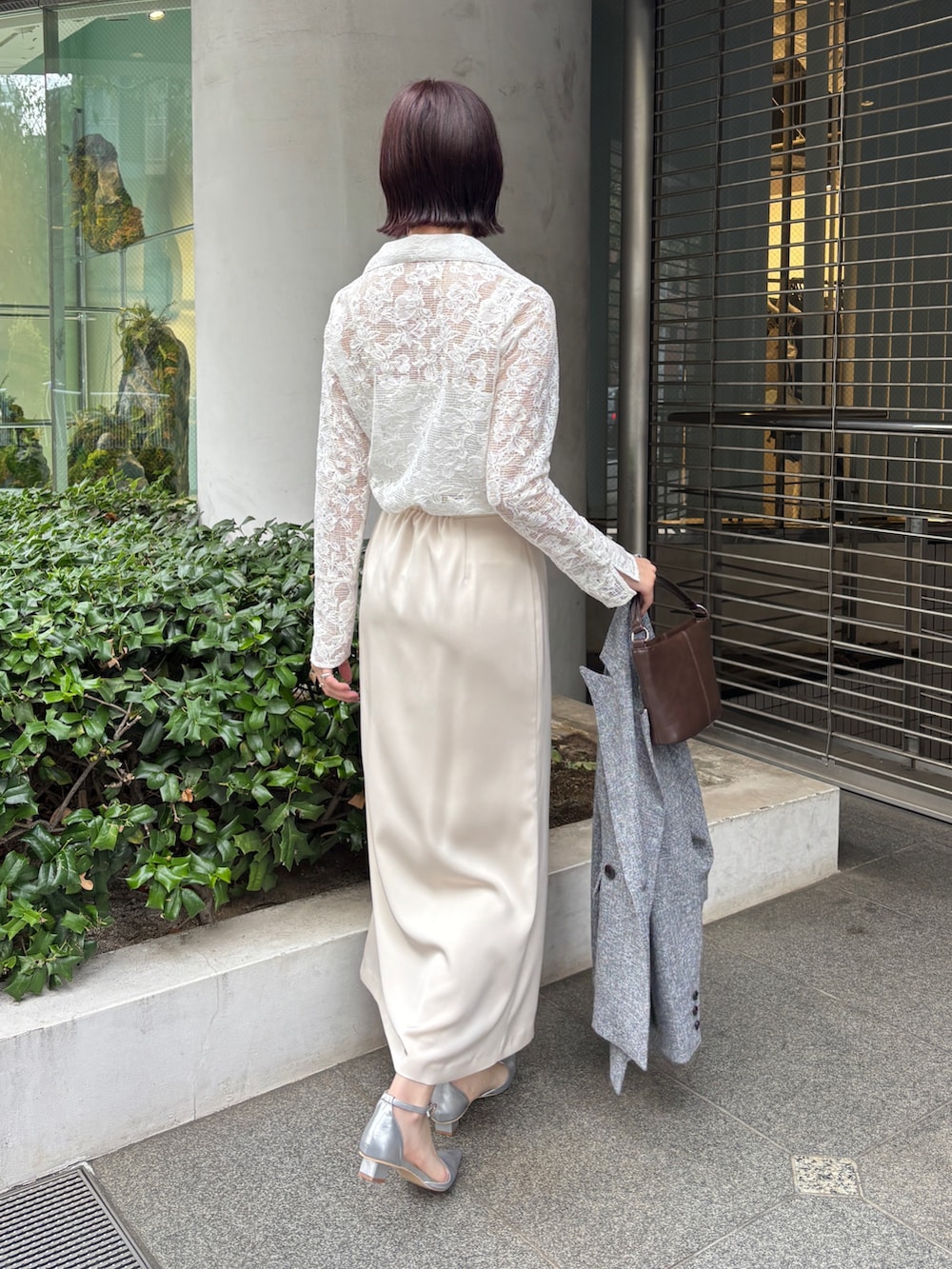 ホワイト系のスカート、ブラック系のテーラードジャケット、シルバー系のパンプスを着用したレディースの冬コーディネートの2枚目の写真