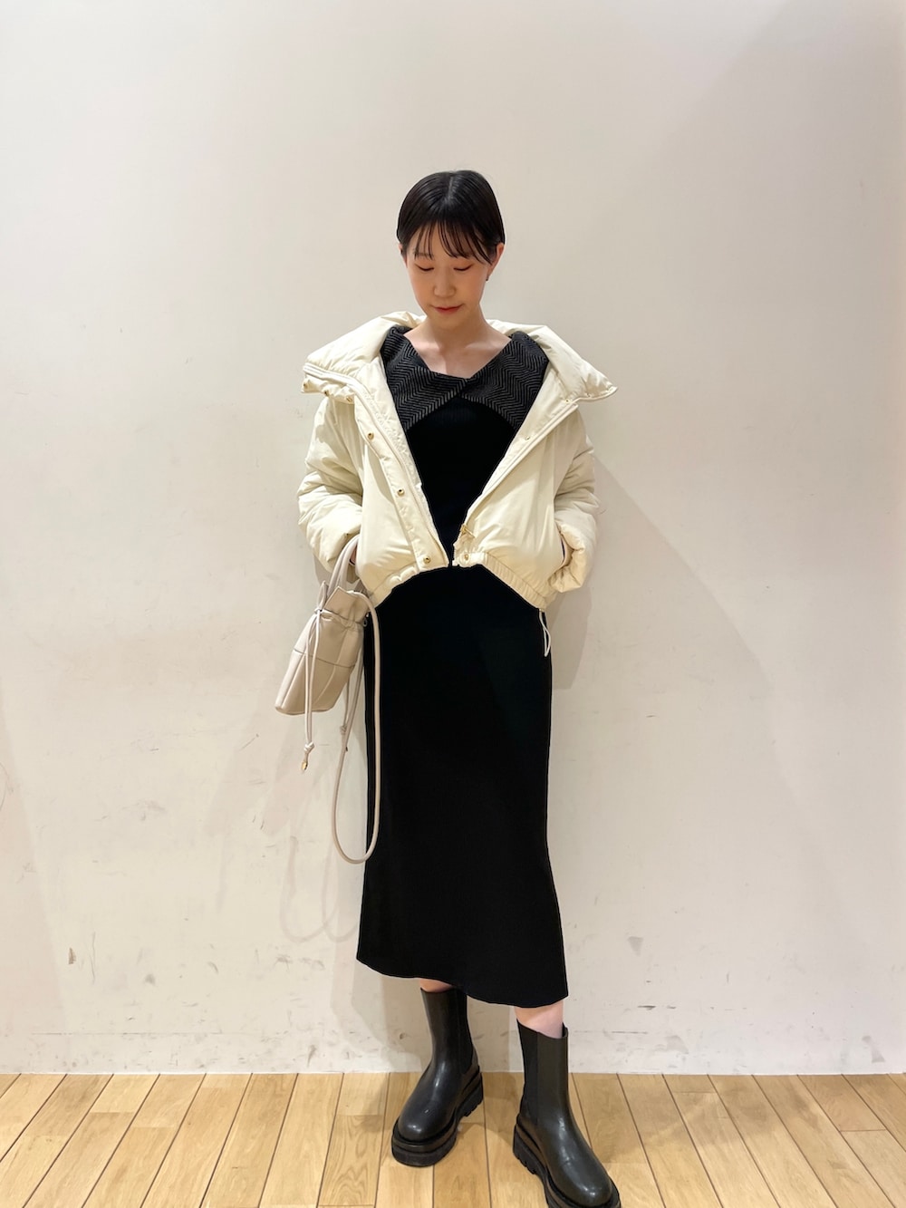 ホワイト系のダウンジャケット/コート、ブラック系のワンピース、ブラック系のブーツを着用したレディースの冬コーディネートの3枚目の写真