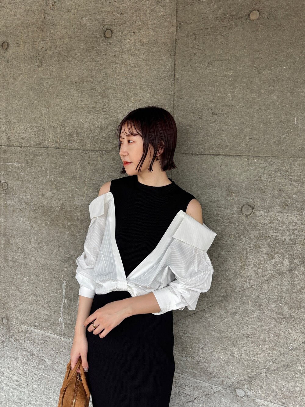 ブラック系のブーツ、イエロー系のハンドバッグ、ブラック系のワンピースを着用したレディースの秋コーディネートの4枚目の写真