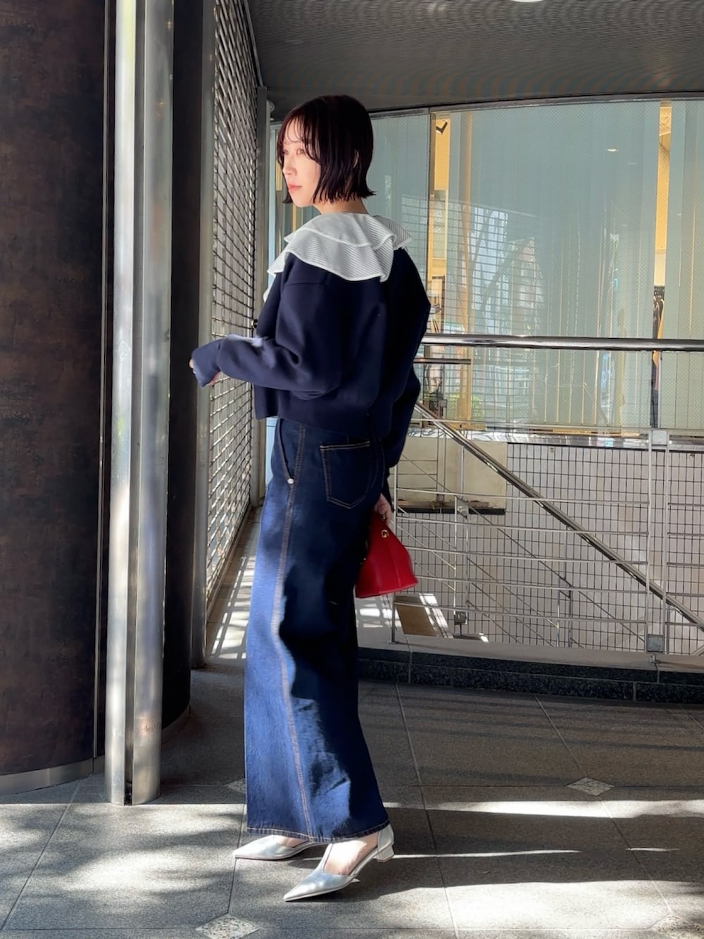 ホワイト系のシャツ/ブラウス、ブルー系のカーディガン/ボレロ、レッド系のハンドバッグを着用したレディースの冬コーディネートの3枚目の写真