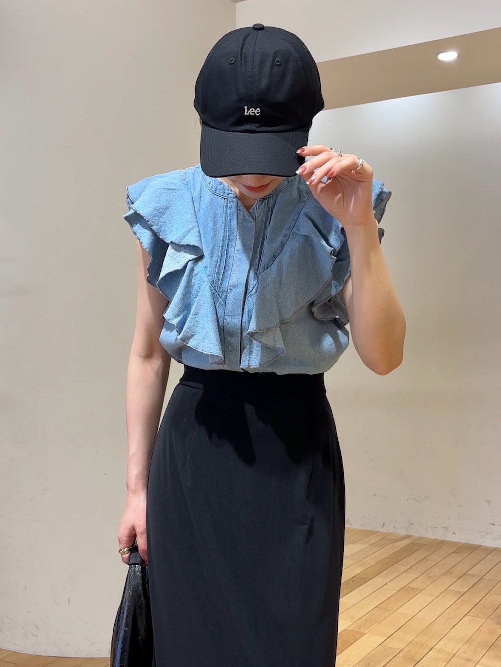 ブルー系のシャツ/ブラウス、ブラック系のスカート、ブラック系のキャップを着用したレディースの夏コーディネートの4枚目の写真
