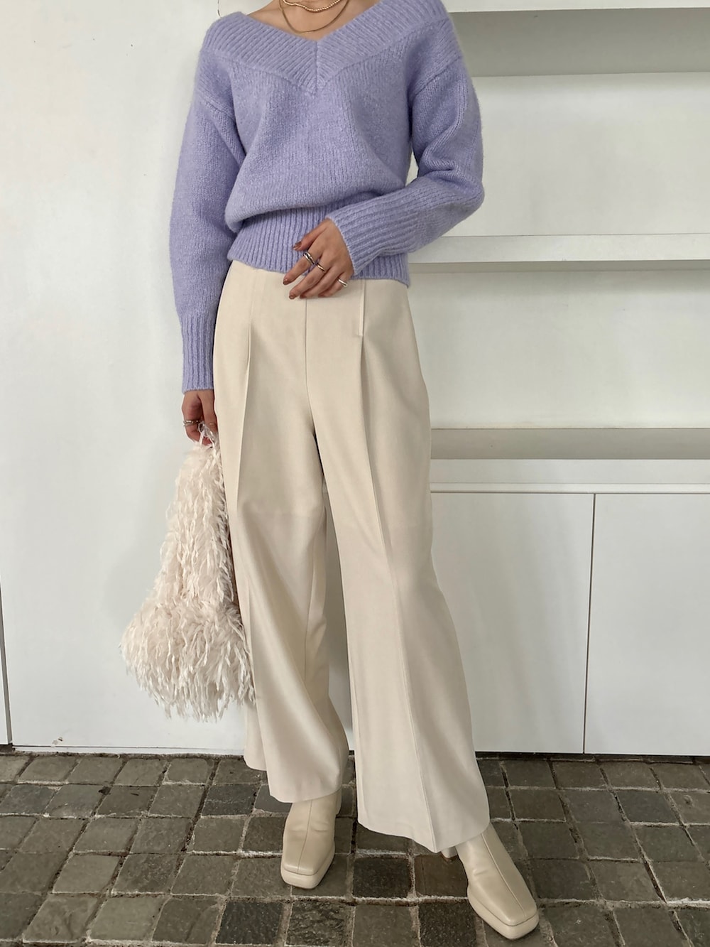 ホワイト系のその他パンツ、パープル系のニット/セーター、ブラック系のブーツを着用したレディースの冬コーディネートの7枚目の写真