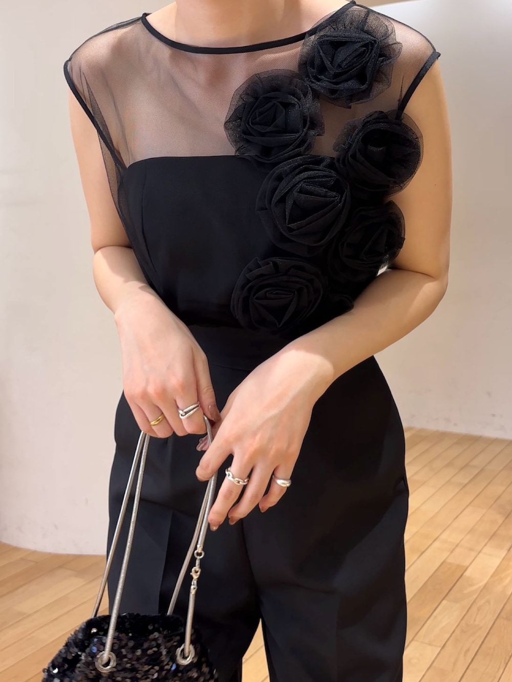 ブラック系のパンツドレス、ブラック系のショルダーバッグ、その他のパンプスを着用したレディースの春コーディネートの5枚目の写真