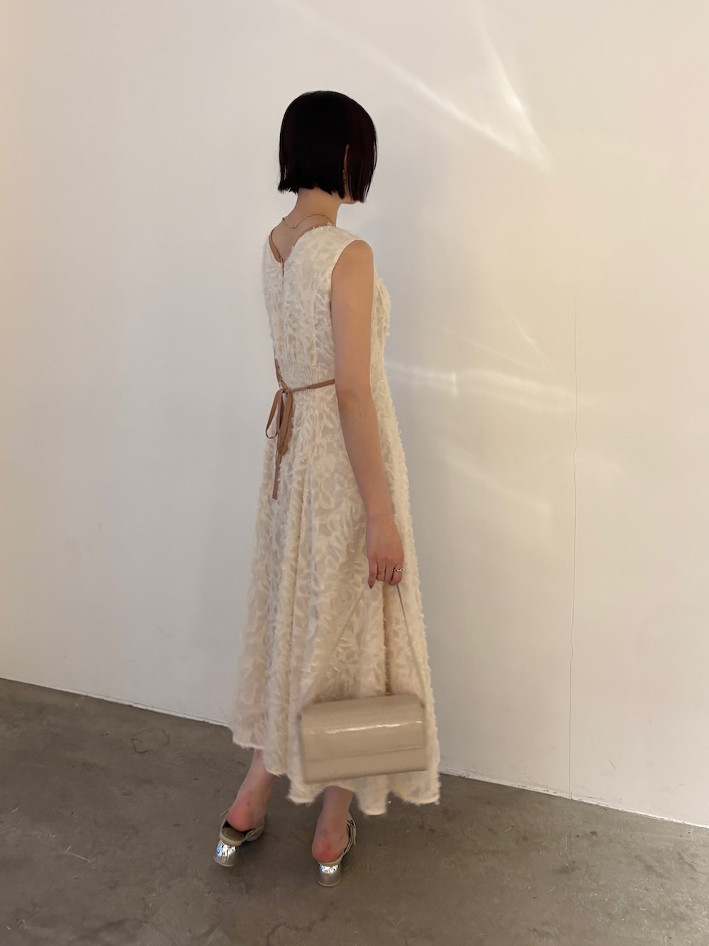 ホワイト系のワンピース、グリーン系のパンプスを着用したレディースの春コーディネートの2枚目の写真