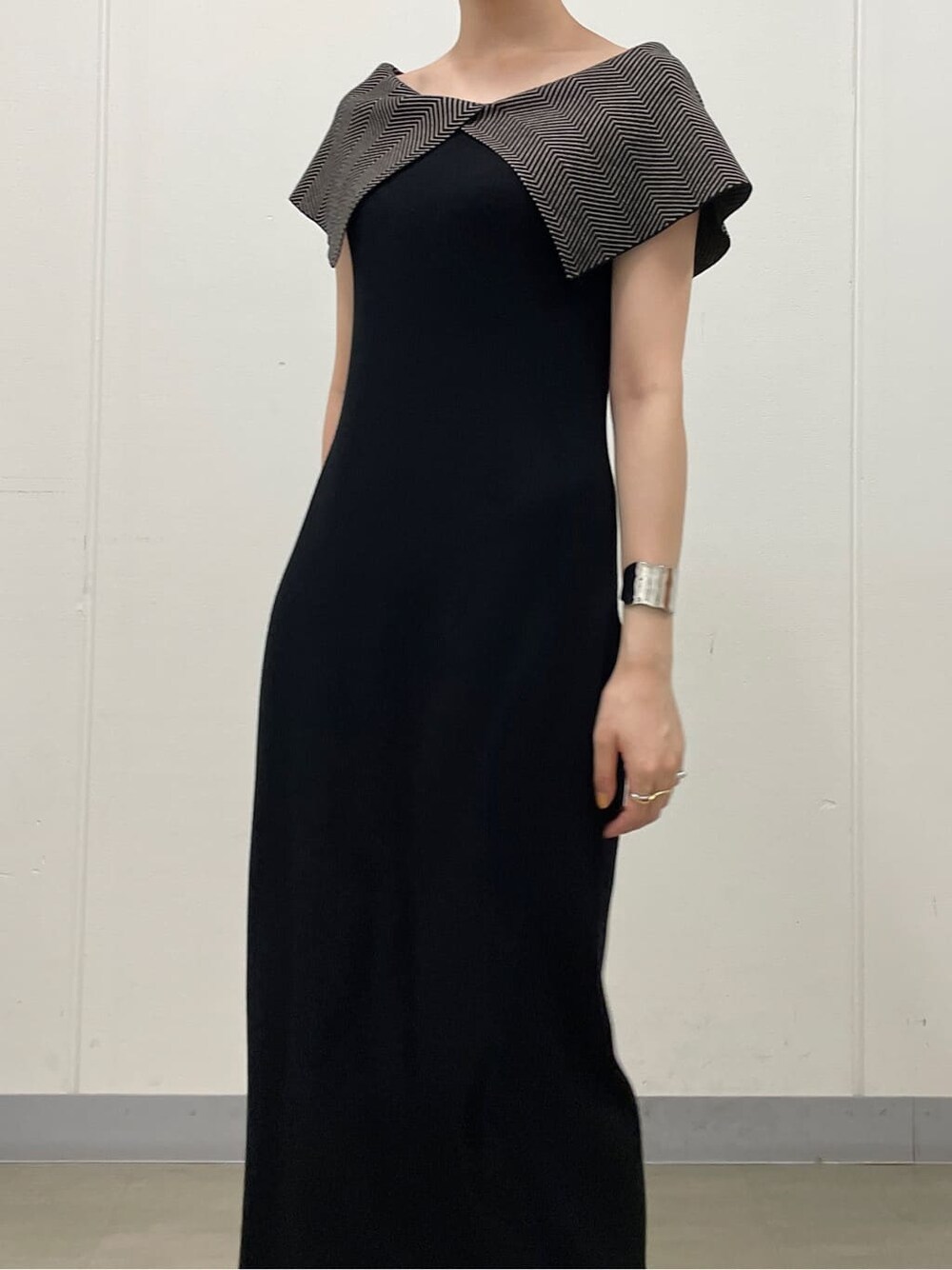 ホワイト系のサンダル、ブラック系のワンピース、シルバー系のバングル/リストバンドを着用したレディースの夏コーディネートの6枚目の写真