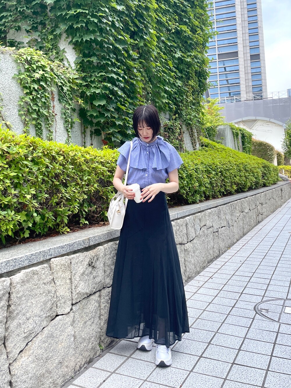 ホワイト系のショルダーバッグ、ブルー系のシャツ/ブラウス、ブラック系のスカートを着用したレディースの夏コーディネートの2枚目の写真