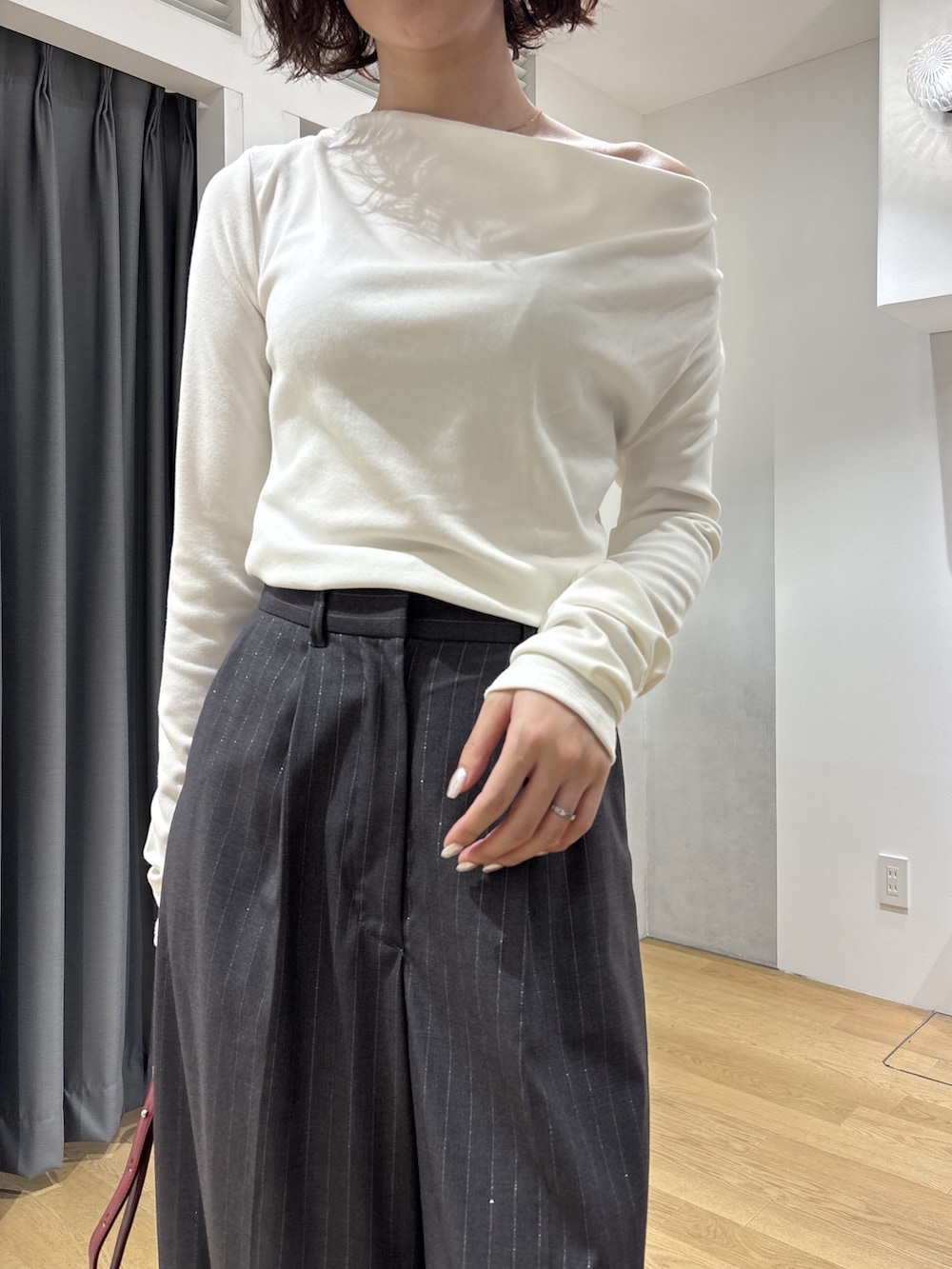 グレー系のその他パンツ、ホワイト系のニット/セーター、レッド系のハンドバッグを着用したレディースの秋コーディネートの10枚目の写真