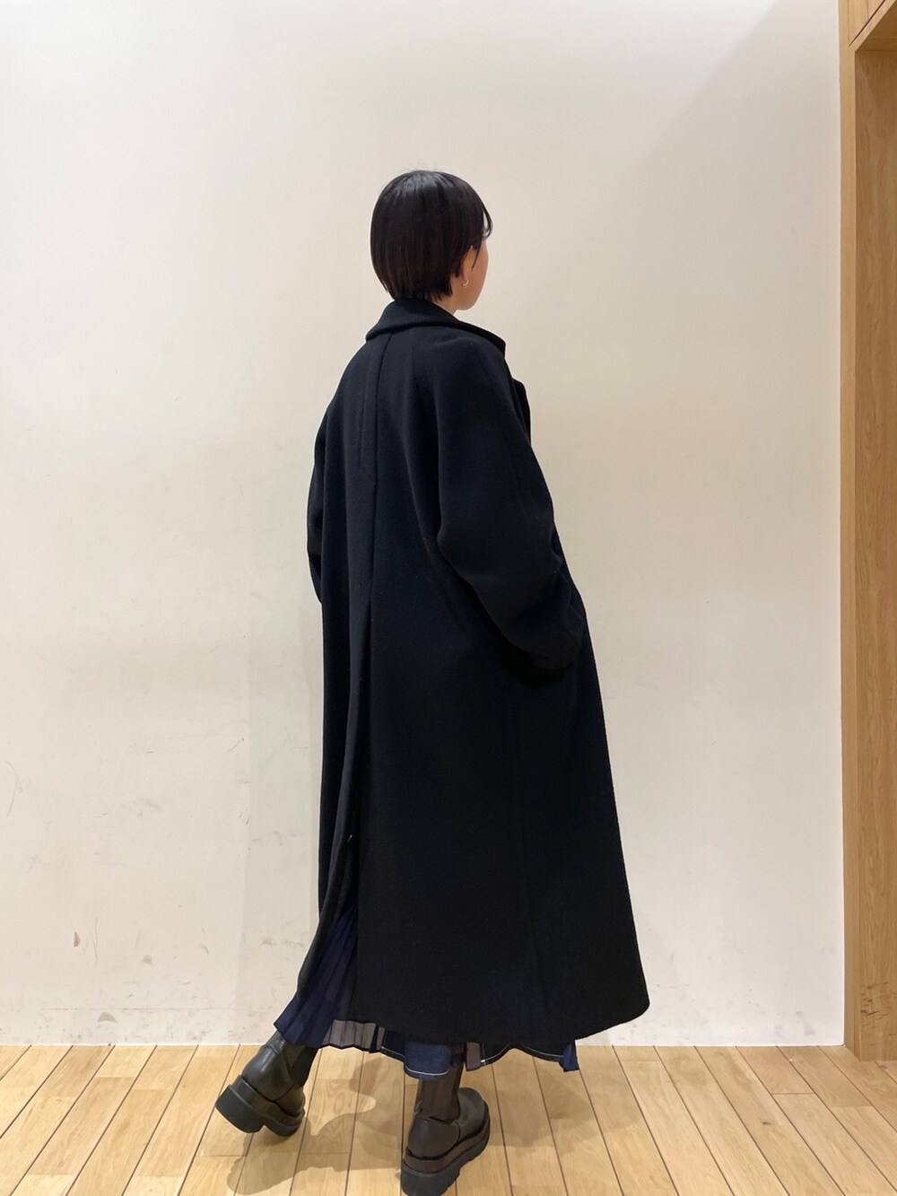 ブラック系のその他アウター、ホワイト系のニット/セーター、ブルー系のスカートを着用したレディースの冬コーディネートの5枚目の写真