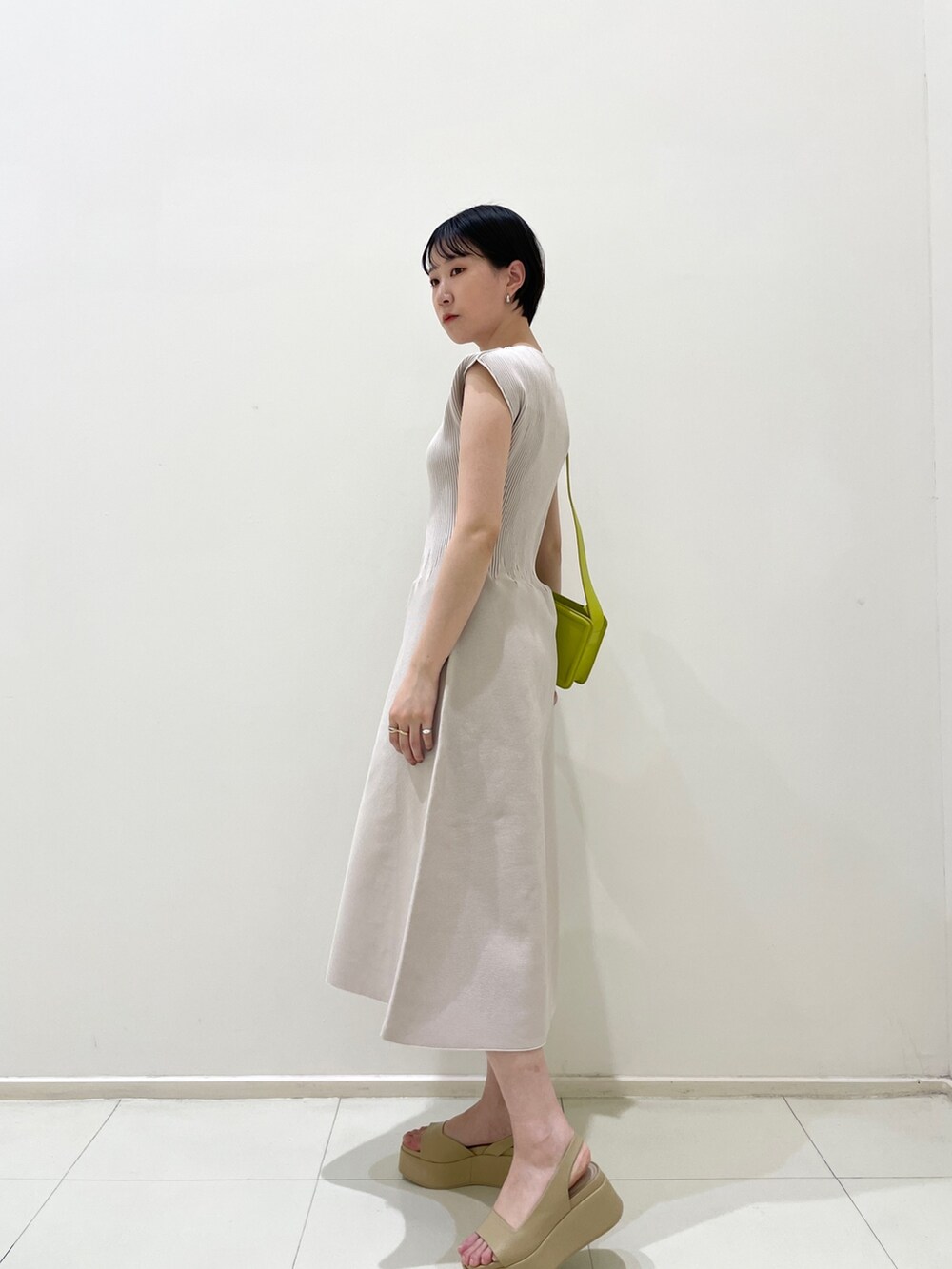 ベージュ系のサンダル、グリーン系のショルダーバッグ、グレー系のワンピースを着用したレディースの春コーディネートの3枚目の写真