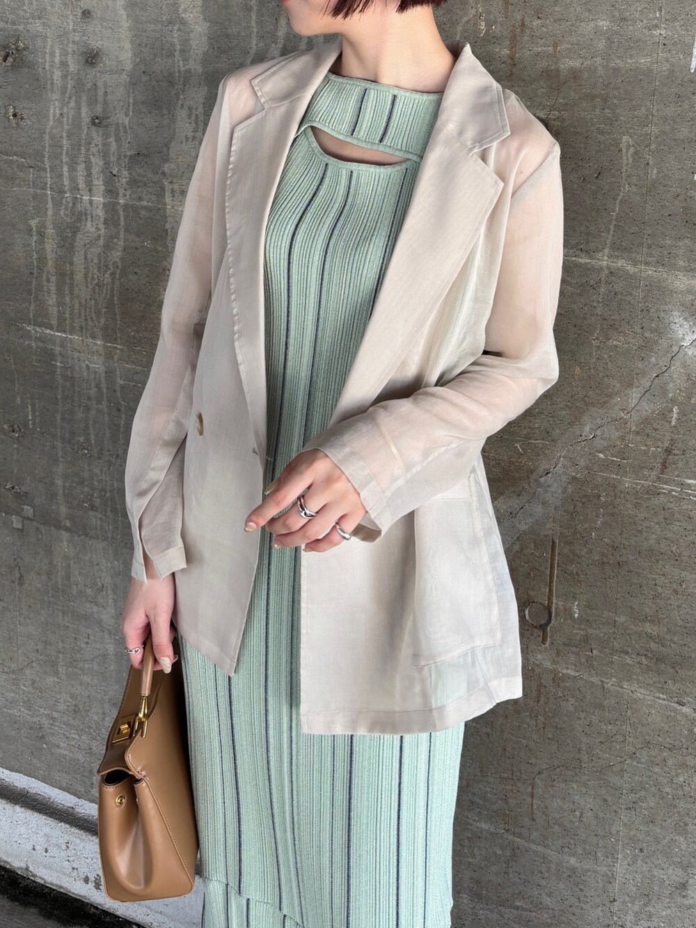 グリーン系のワンピース、ホワイト系のテーラードジャケット、ブラック系のサンダルを着用したレディースの春コーディネートの5枚目の写真