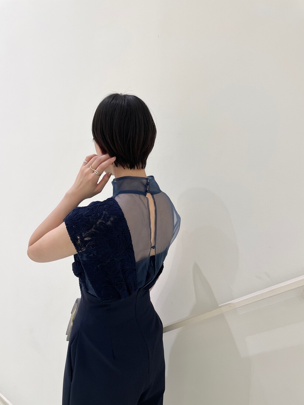 ブルー系のパンツドレス、グレー系のクラッチバッグ、グレー系のパンプスを着用したレディースの冬コーディネートの10枚目の写真