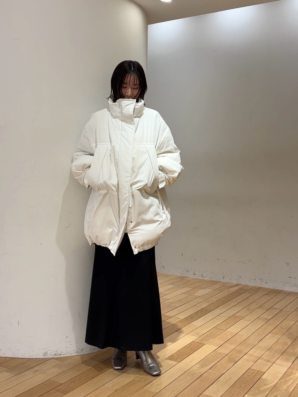 ブラック系のスカート、パープル系のニット/セーター、ホワイト系のダウンジャケット/コートを着用したレディースの冬コーディネートの5枚目の写真