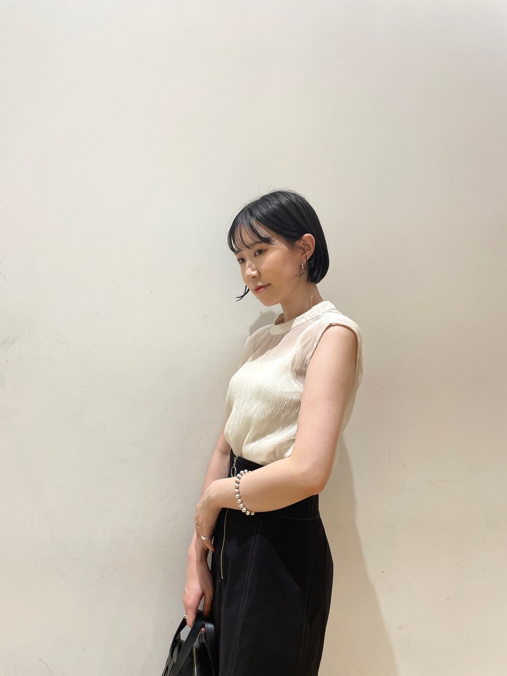 ホワイト系のシャツ/ブラウス、ブラック系のスカート、ブラック系のショルダーバッグを着用したレディースの夏コーディネートの6枚目の写真