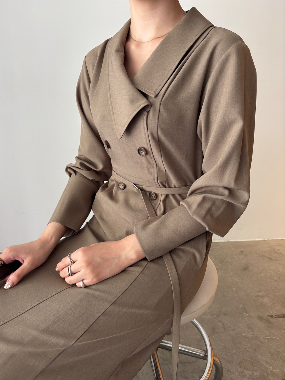 ホワイト系のワンピース、ブラウン系のハンドバッグ、ブラウン系のブーツを着用したレディースの秋コーディネートの7枚目の写真