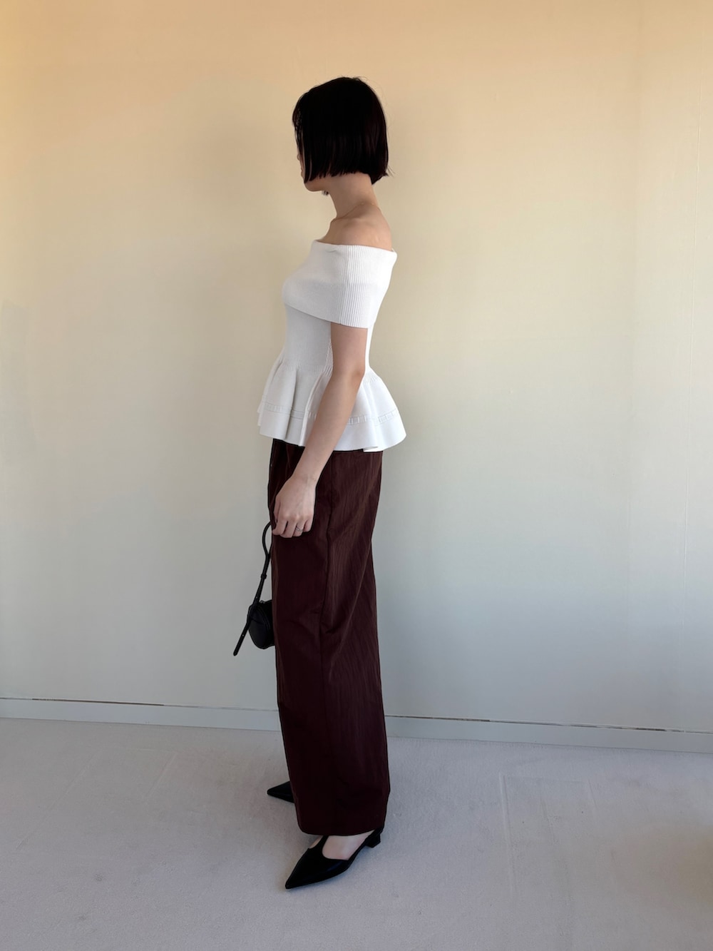 ブラウン系のその他パンツ、ブラック系のパンプス、ホワイト系のニット/セーターを着用したレディースの春コーディネートの3枚目の写真
