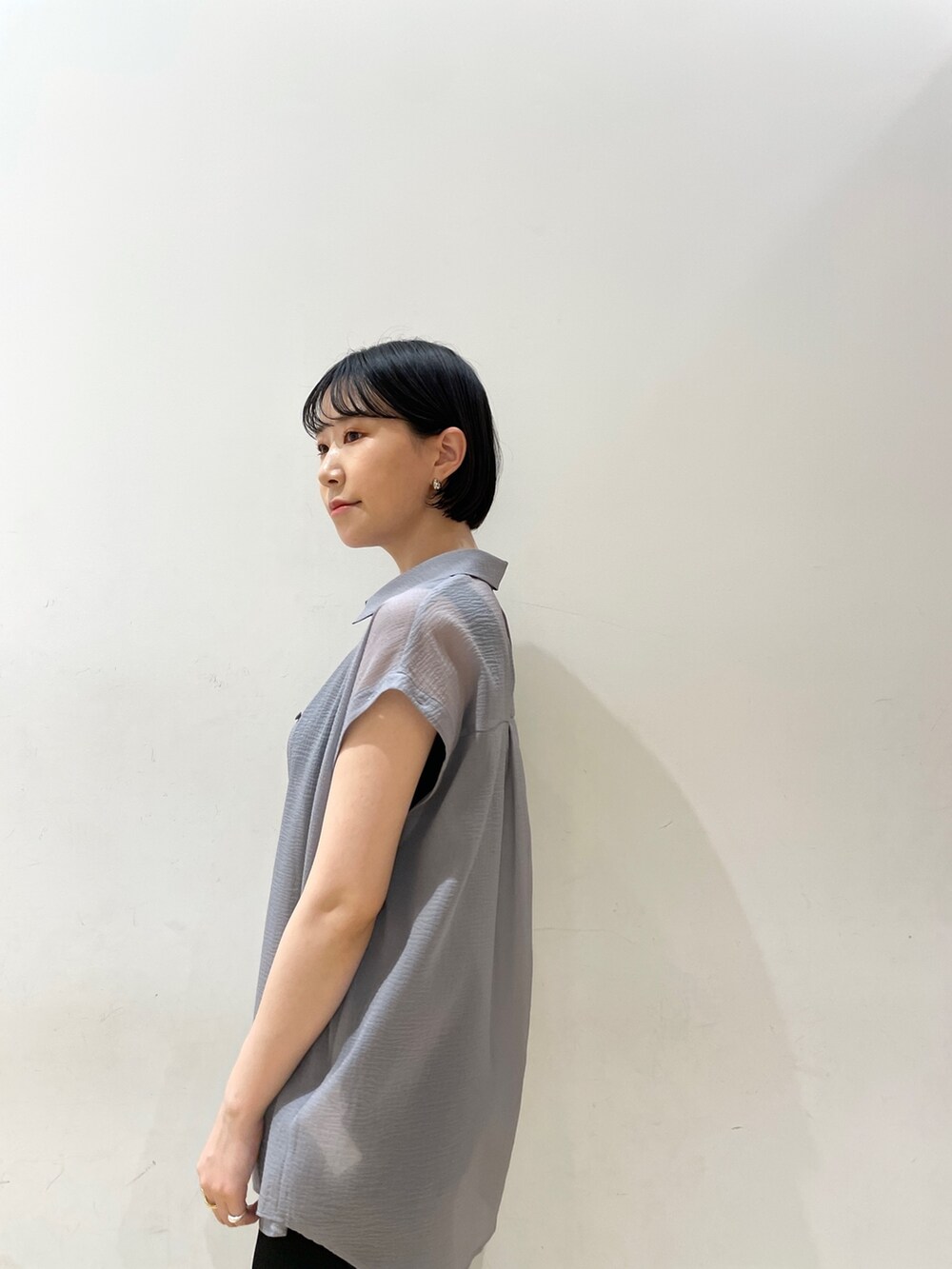 ブラック系のスカート、ブラウン系のハンドバッグ、ブラック系のサンダルを着用したレディースの春コーディネートの8枚目の写真