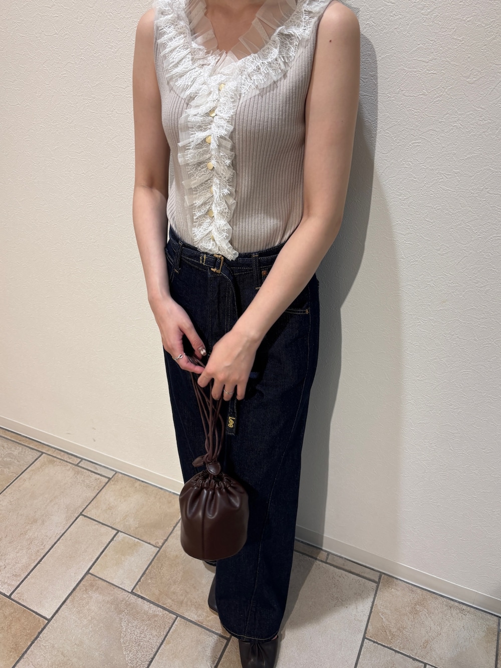 ベージュ系のニット/セーター、ブルー系のデニムパンツ、ブラウン系のサンダルを着用したレディースの夏コーディネートの4枚目の写真
