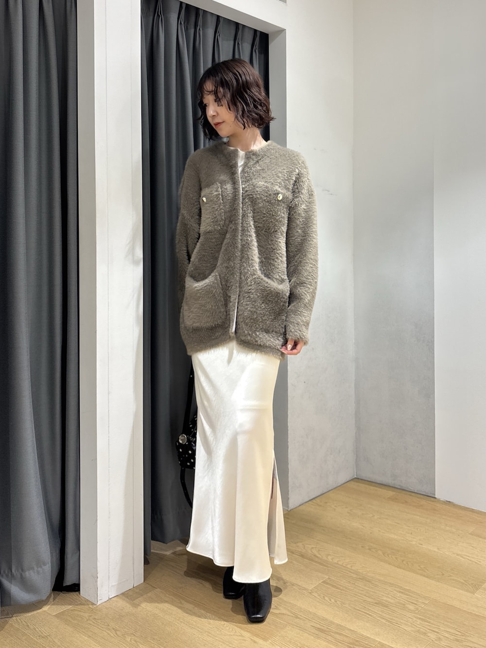 ホワイト系のスカート、ブラウン系のカーディガン/ボレロ、ホワイト系のニット/セーターを着用したレディースの秋コーディネートの2枚目の写真