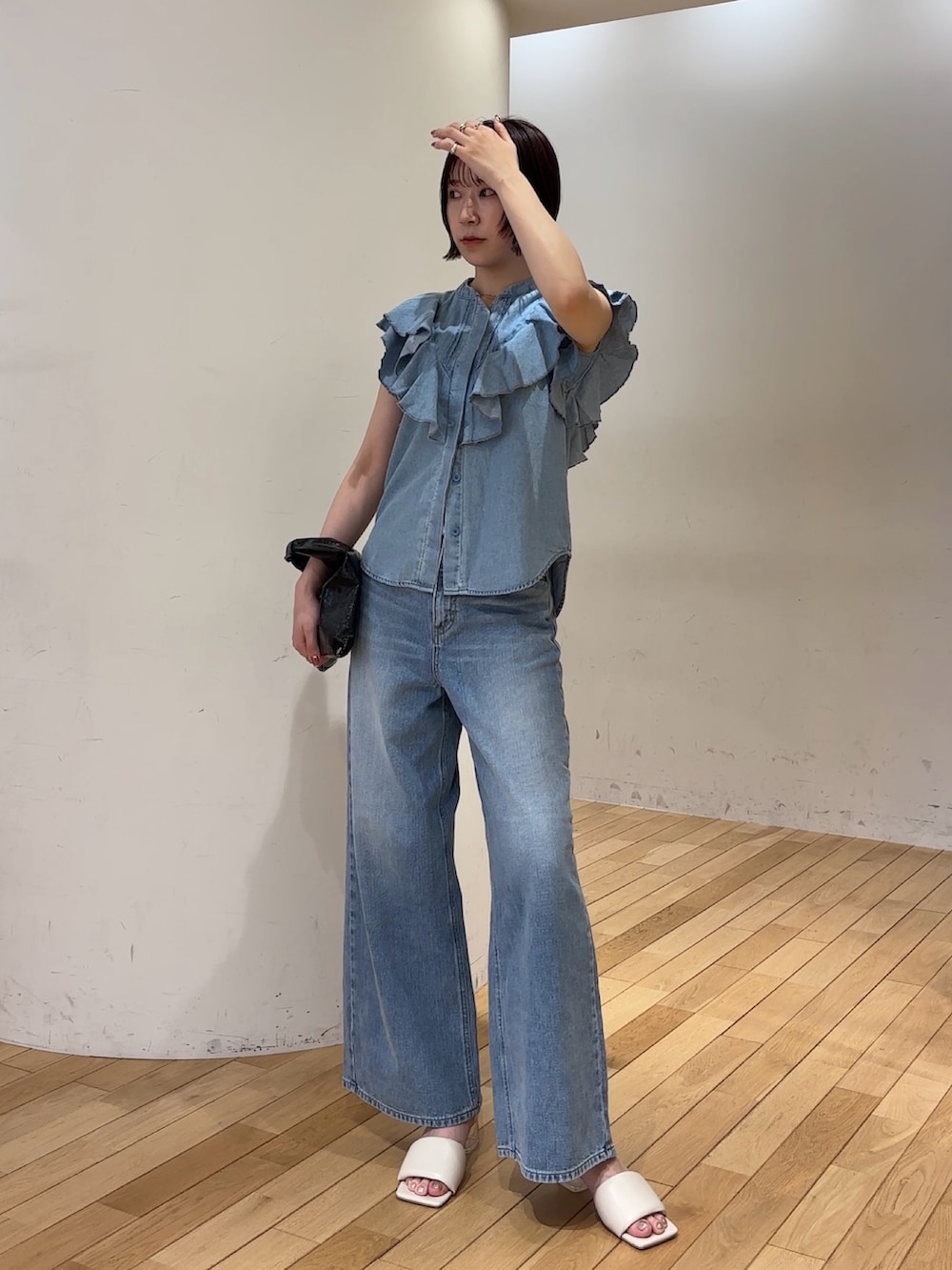 ブルー系のデニムパンツ、ブルー系のシャツ/ブラウス、ホワイト系のサンダルを着用したレディースの夏コーディネートの4枚目の写真