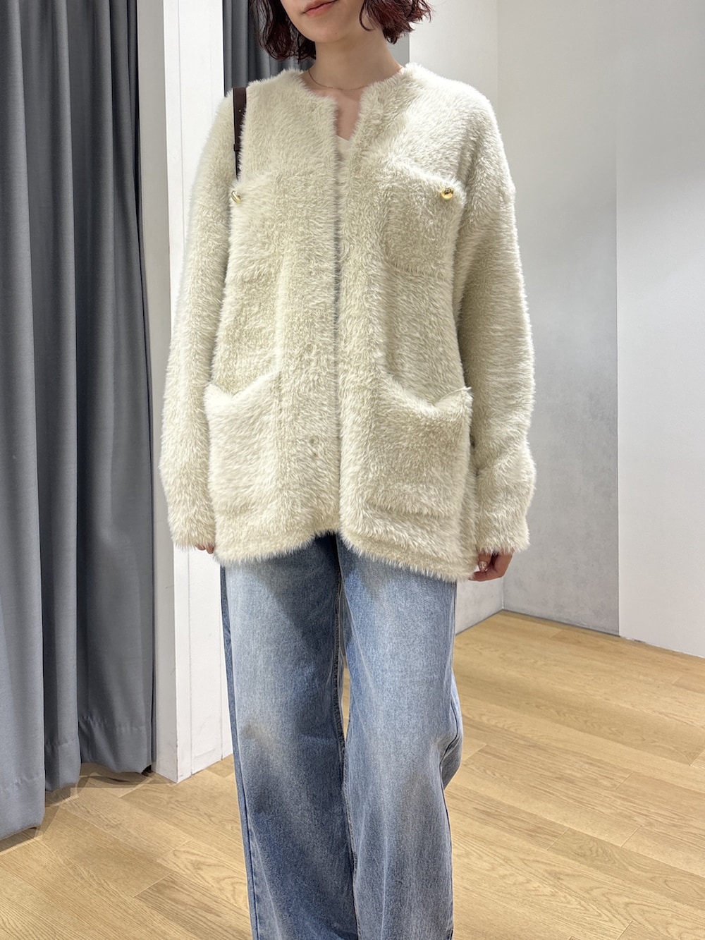 ホワイト系のカーディガン/ボレロ、ブラック系のハンドバッグ、ホワイト系のTシャツ/カットソーを着用したレディースの秋コーディネートの6枚目の写真
