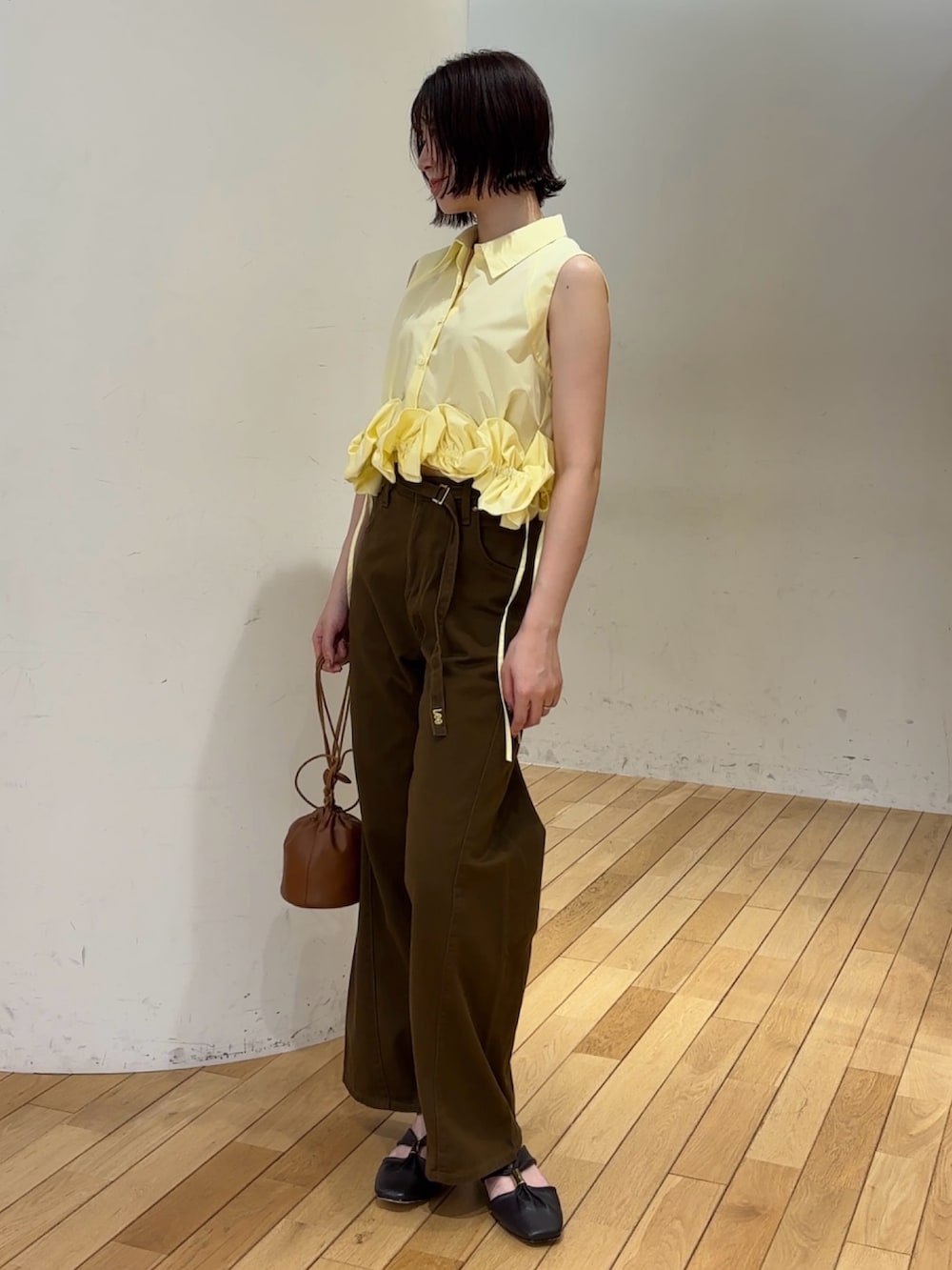 ブラウン系のデニムパンツ、イエロー系のシャツ/ブラウス、イエロー系のハンドバッグを着用したレディースの夏コーディネートの2枚目の写真