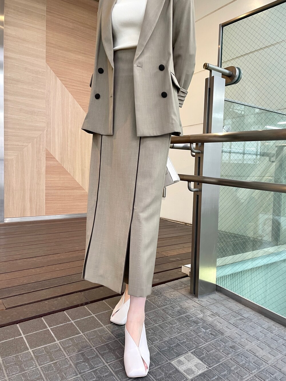 ホワイト系のパンプス、ブラウン系のテーラードジャケット、ホワイト系のニット/セーターを着用したレディースの春コーディネートの7枚目の写真