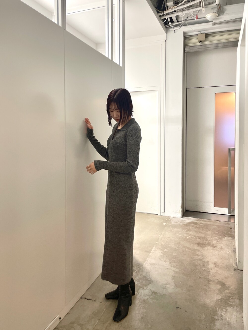 ブラック系のブーツ、グレー系のワンピースを着用したレディースの春コーディネートの3枚目の写真