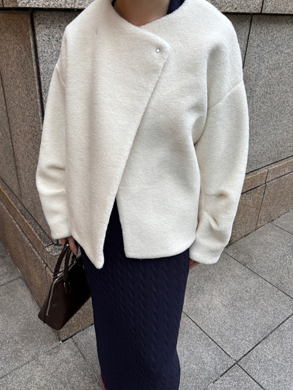 ホワイト系のブルゾン、ブルー系のワンピース、ブラウン系のボストンバッグを着用したレディースの秋コーディネートの7枚目の写真