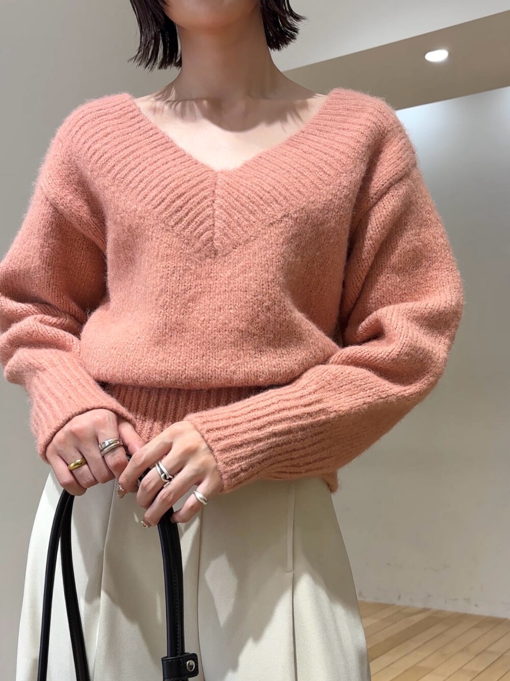 ピンク系のニット/セーター、ブラック系のショルダーバッグ、ホワイト系のその他パンツを着用したレディースの冬コーディネートの5枚目の写真