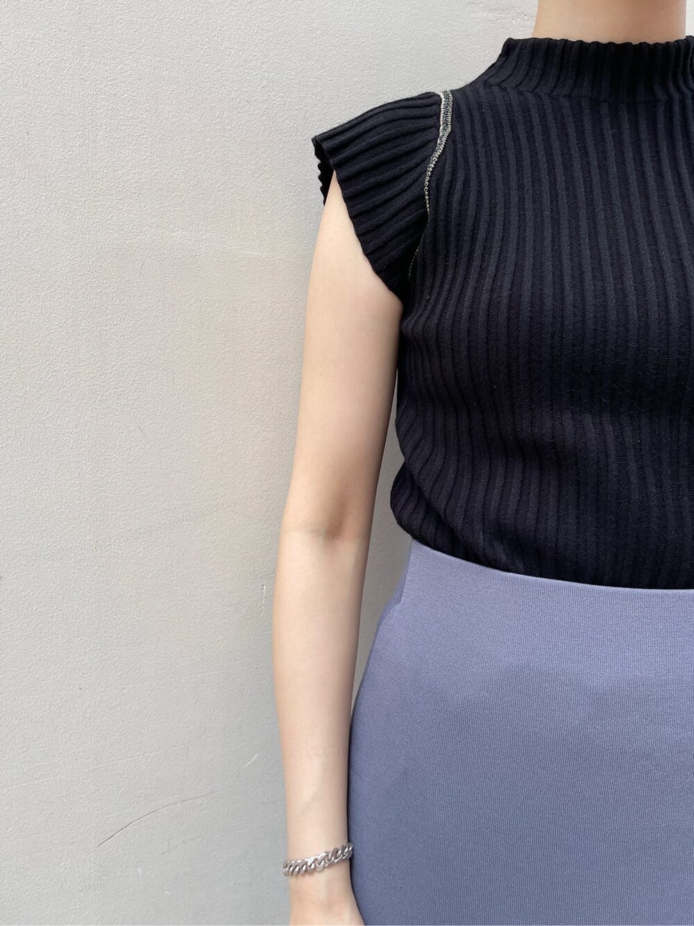 ホワイト系のサンダル、ブルー系のスカート、ブラック系のニット/セーターを着用したレディースの夏コーディネートの8枚目の写真