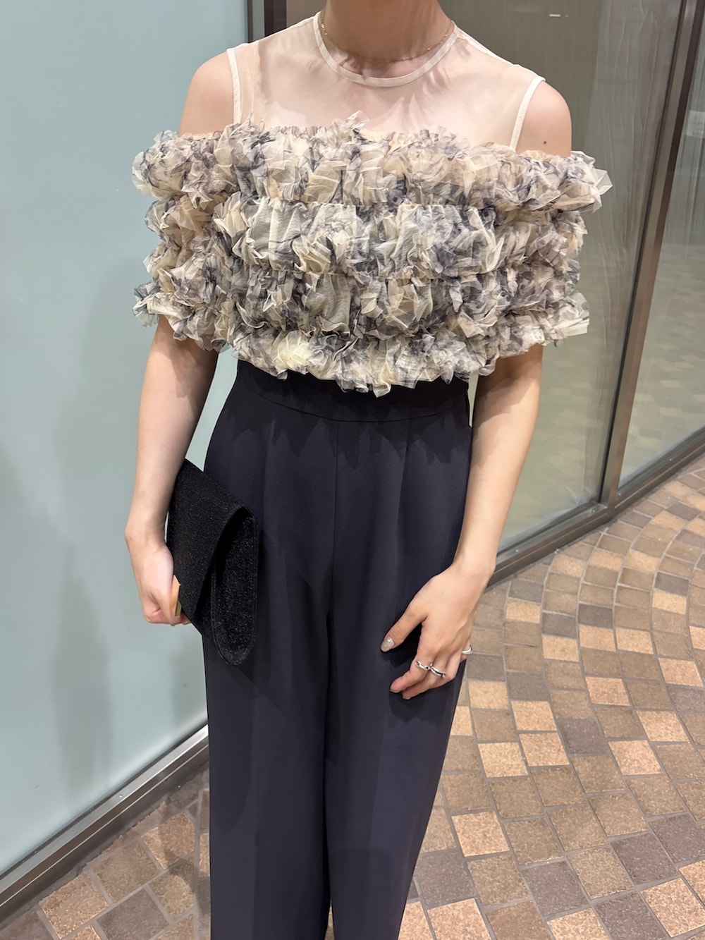 グレー系のパンツドレス、ブラック系のクラッチバッグ、ブラック系のパンプスを着用したレディースの夏コーディネートの8枚目の写真