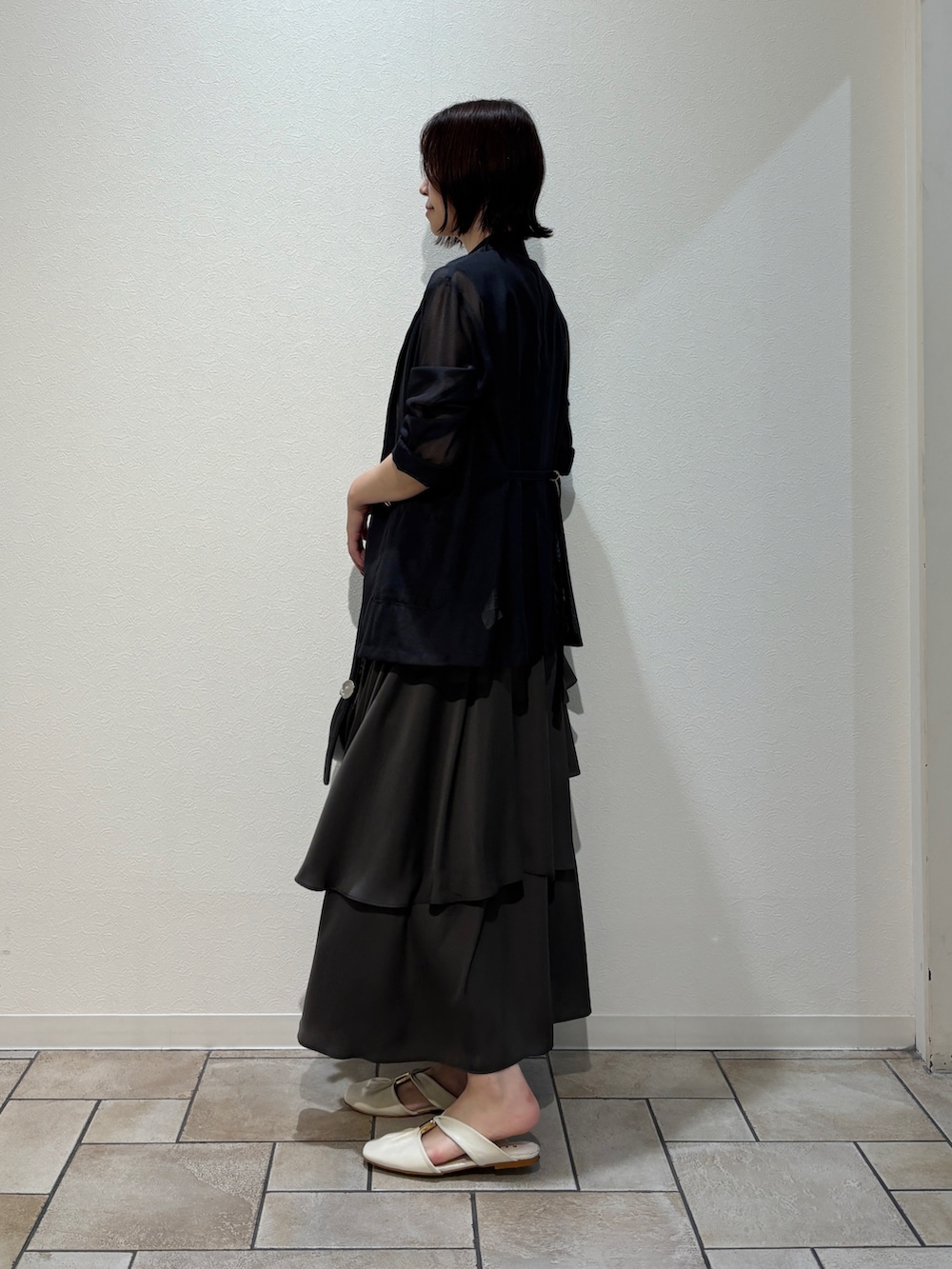 ブラック系のワンピース、ブラック系のハンドバッグ、ホワイト系のサンダルを着用したレディースの夏コーディネートの7枚目の写真