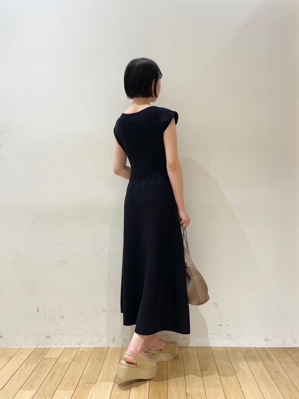 ブラック系のワンピース、ブラウン系のハンドバッグ、ベージュ系のサンダルを着用したレディースの夏コーディネートの4枚目の写真