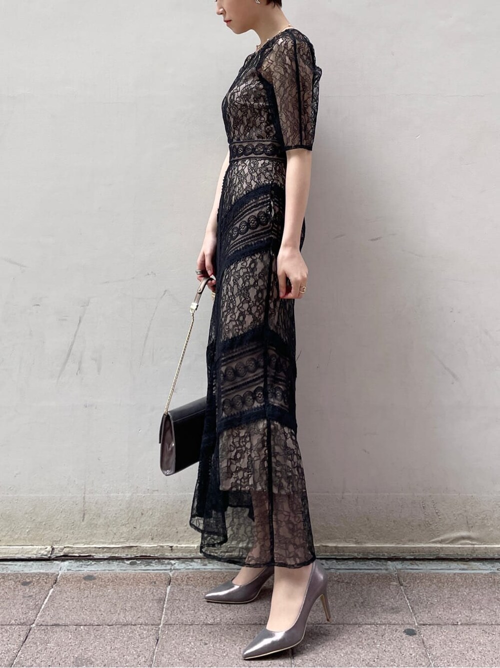 シルバー系のクラッチバッグ、ベージュ系のトレンチコート、シルバー系のパンプスを着用したレディースの冬コーディネートの3枚目の写真