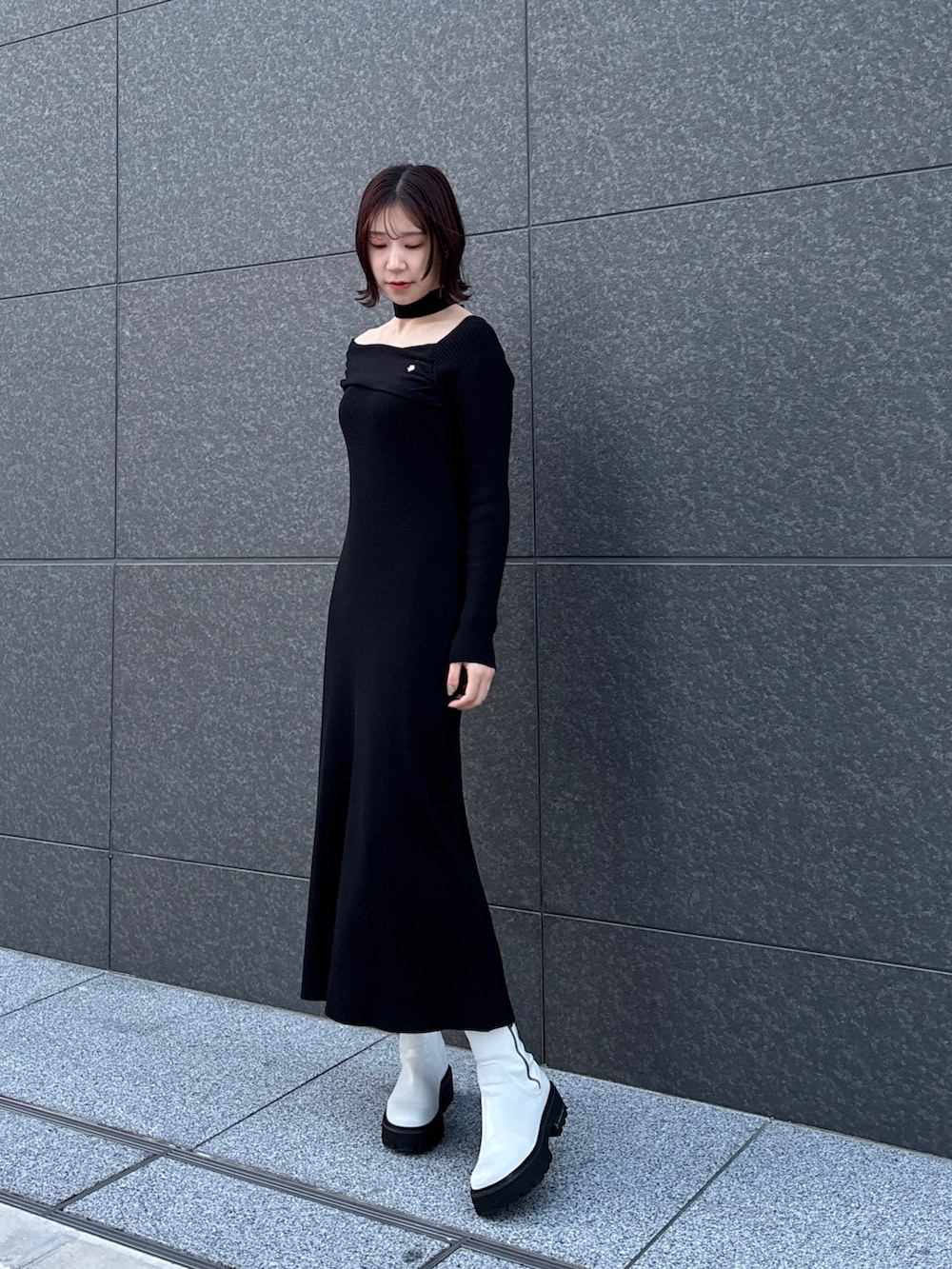 ブラック系のワンピース、グレー系のムートンコートを着用したレディースの冬コーディネートの2枚目の写真