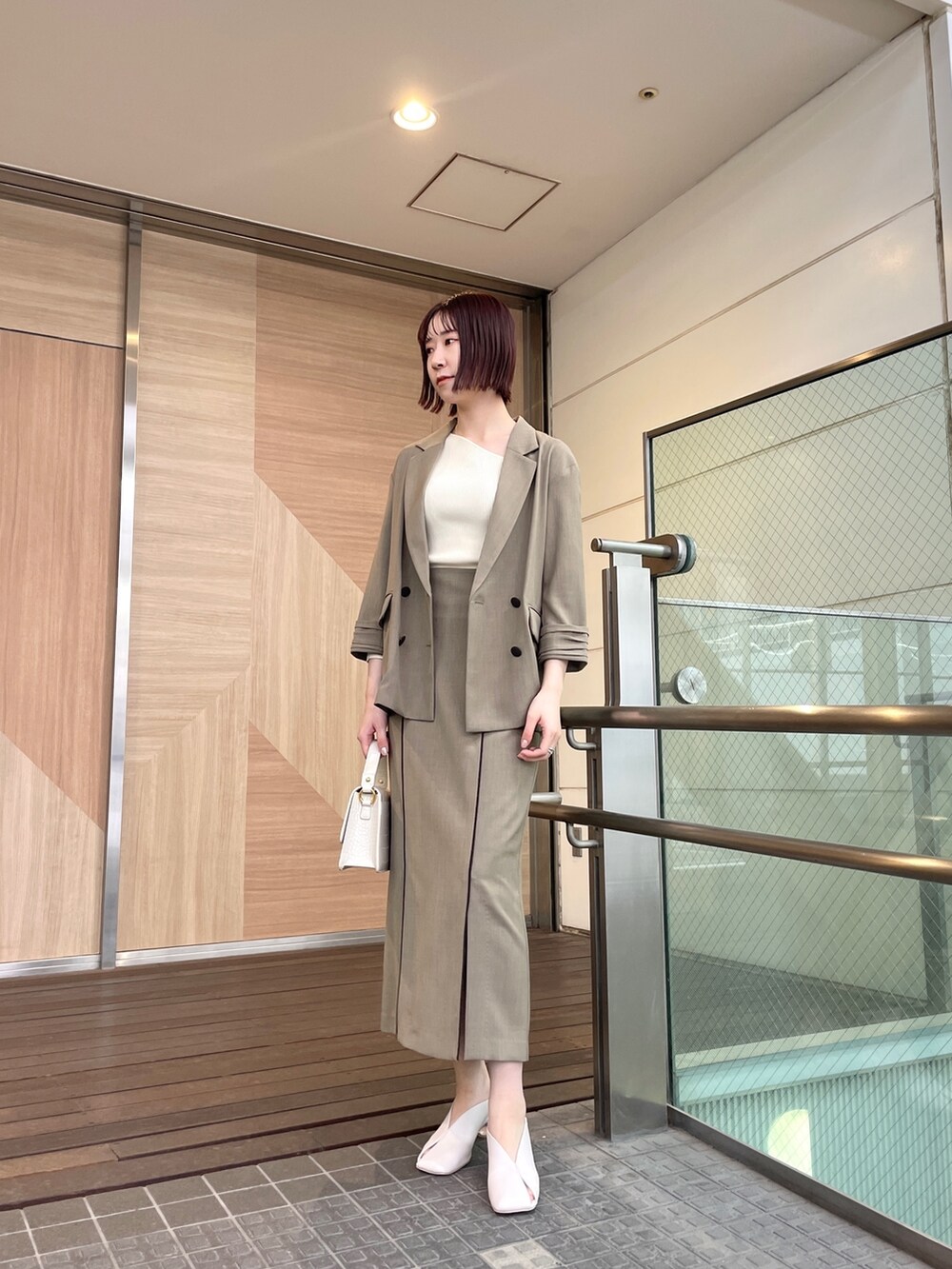 ホワイト系のパンプス、ブラウン系のテーラードジャケット、ホワイト系のニット/セーターを着用したレディースの春コーディネートの2枚目の写真