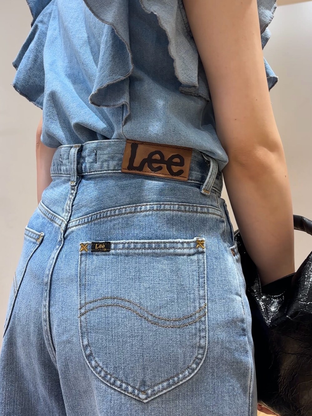 ブルー系のデニムパンツ、ブルー系のシャツ/ブラウス、ホワイト系のサンダルを着用したレディースの夏コーディネートの7枚目の写真