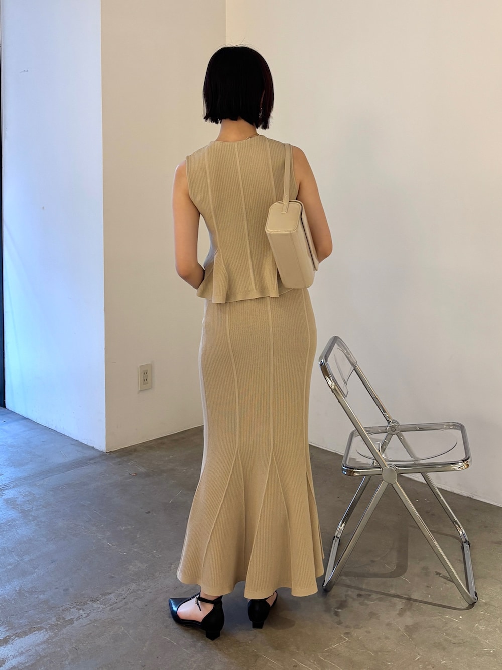 ベージュ系のニット/セーター、ベージュ系のスカート、ブラック系のパンプスを着用したレディースの春コーディネートの3枚目の写真