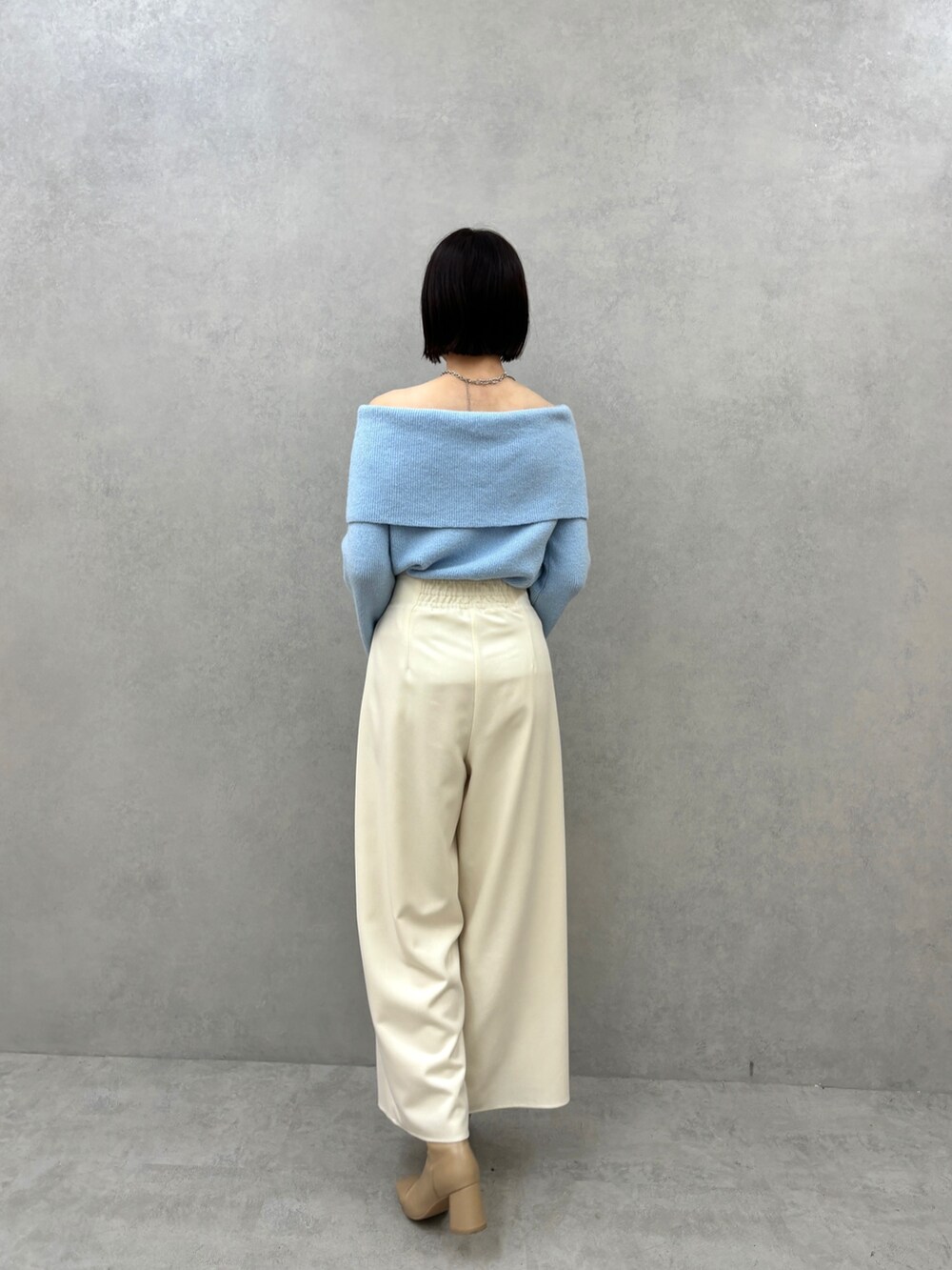 ブルー系のニット/セーター、ホワイト系のその他パンツを着用したレディースの秋コーディネートの4枚目の写真