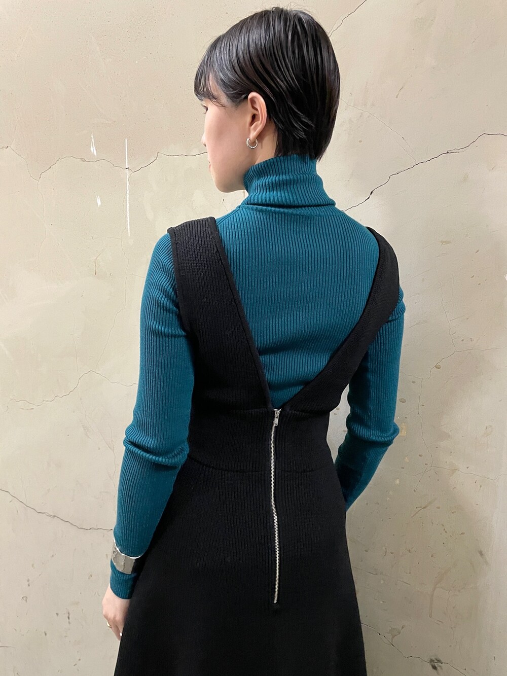 ブラック系のスカート、グリーン系のニット/セーター、ブラック系のブーツを着用したレディースの秋コーディネートの9枚目の写真