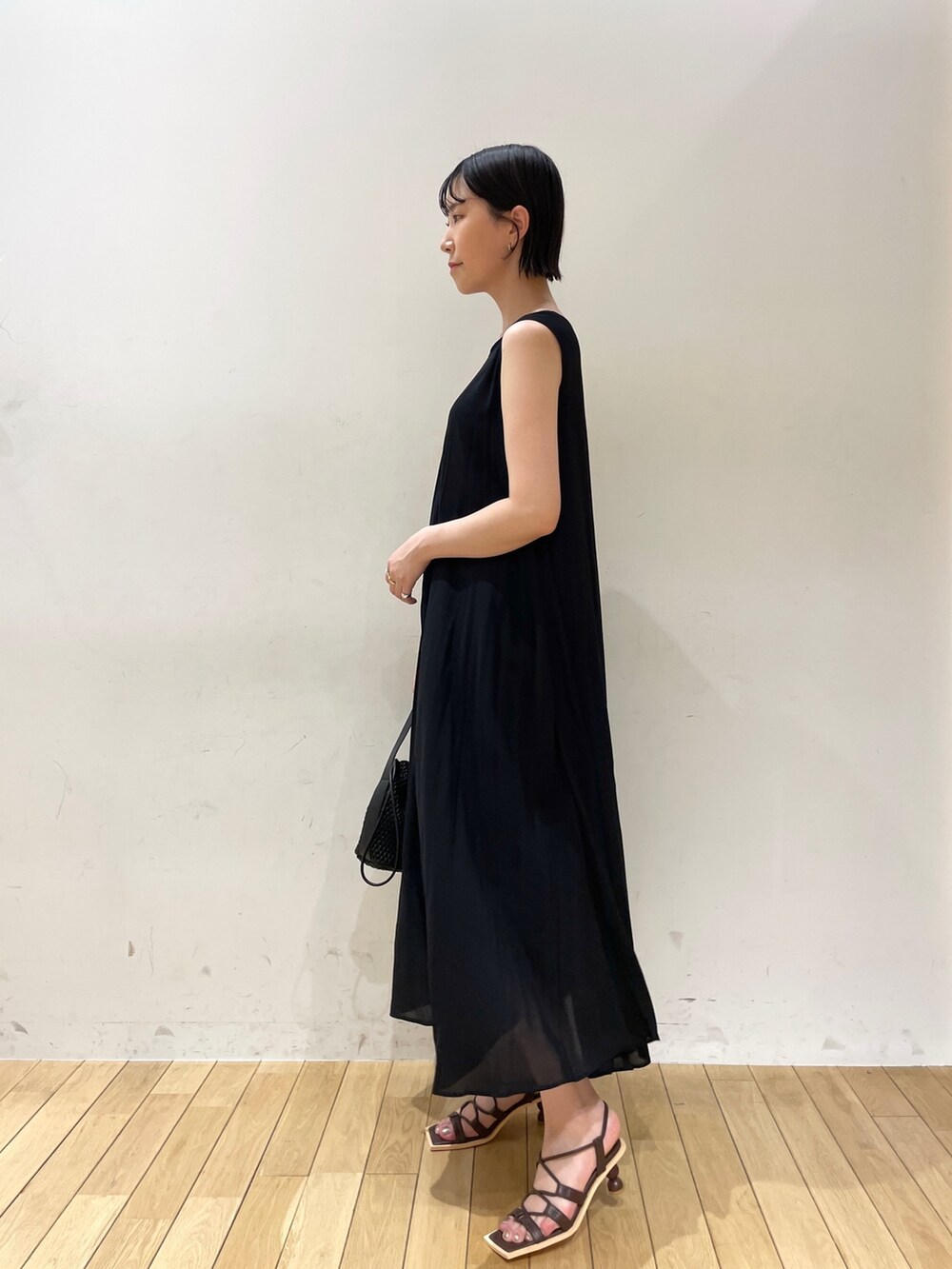 ブラック系のハンドバッグ、ベージュ系のテーラードジャケット、ブラック系のワンピースを着用したレディースの夏コーディネートの4枚目の写真