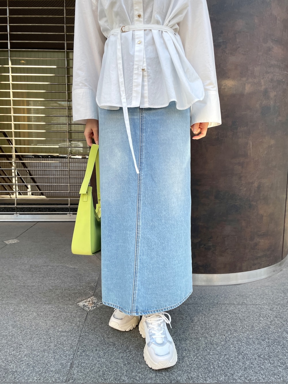 ホワイト系のシャツ/ブラウス、グリーン系のデニムスカート、ホワイト系のスニーカーを着用したレディースの春コーディネートの8枚目の写真